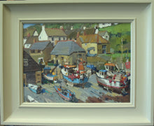 Load image into Gallery viewer, Lots of boats moored on the sand in the foreground, with a backdrop of cottages and a green hill behind and peek of blue sky in the top left corner. Also shows the wide scooped frame painted a light stone colour.
