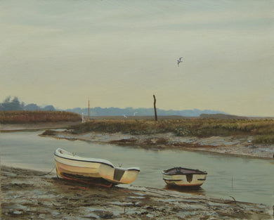 Two boats on the mud at the Norfolk harbour, with a greyish sky and three guls on the wing.
