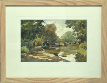 Load image into Gallery viewer, 6.5 x 10 inch watercolour of the canal at Braunston, with several narrowboats moored along the towpah which curves from the front left of the picture, curving around to the distant trees on the right.  Shows the plain Oak frame with a single cream, grooved mount
