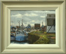 Load image into Gallery viewer, 9 x 12 inch oil painting, painted en plein air at Grimsby Docks, with various boats in the middle distance, the edge of a building on the right, a lively, cloudy sky, and two fishing boats in the foreground and a figure with orange high viz overall on, walking away from us. Shows the buff-coloured frame with grey outer edge and off-white inner slip.
