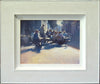 9 x 12 inch acrylic painting by Carl Knibb, depicting lots of people outside a street cafe, sitting on tables, enjoying a chat over lunch, again looking into the sunlight, with strong, blue shadows cast on the pavement around them. Shows whitewashed frame.