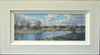 A panoramic 8 x 20 inch acrylic painting, depicting a river with distant blue skyline of trees, loosely described trees on the far bank, and a lively sky.  Shows whitewashed frame