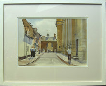 Load image into Gallery viewer, Watercolour of the entrance gates to Uppingham School, with a few pupils walking on the pavements and under the archway, with honey-coloured stone of the towering facade on the right. White frame moulding and double cream/white mount.
