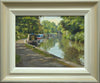9 x 12 inch oil painting of narrowboats moored next to the towpath on the left, with a bridge in the distance, trees reflected in the calm waters. Also shows frame with off-white slip, gradating to beige/grey outer frame.