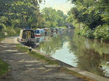 Load image into Gallery viewer, 9 x 12 inch oil painting of narrowboats moored next to the towpath on the left, with a bridge in the distance, trees reflected in the calm waters.
