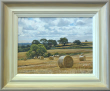 Load image into Gallery viewer, 9 x 12 inch oil of round bales of straw on a hill sloping down from right to left, with distant trees and some nearer trees in the middle distance. Shows hand-finished frame, with gradated colours from off-white inner to beige/grey outer.
