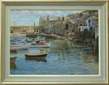 Load image into Gallery viewer, 22 x 30 inch oil painting of many boats on the water in Mousehole harbour at high tide, with all the stone houses around the harbour wall and figures talking together. Shows the gold-leafed outer edged frame, with green/grey middle and stone-coloured inner with off-white inner edge.
