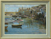 22 x 30 inch oil painting of many boats on the water in Mousehole harbour at high tide, with all the stone houses around the harbour wall and figures talking together. Shows the gold-leafed outer edged frame, with green/grey middle and stone-coloured inner with off-white inner edge.