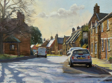 6 x 8 inch oil of the main street in Lyddington in Rutland, looking into the sunlight, with chimneys silhouetted against the sunlight, with a strong shadow of a tree across the road and a couple of parked cars.