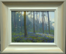 Load image into Gallery viewer, 6 x 8 inch oil painting of Pine trees at Barnsdale Wood, looking straight into the sunlight, with bluebells beneath,, showing hand-finished grey outer to beige and off-white inner frame
