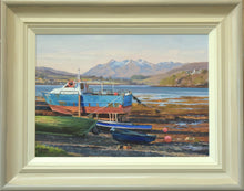 Load image into Gallery viewer, 10 x 14 oil painting of a bright blue and red-hulled boat in dry dock, sunny blue sky and the Cuillin Mountains in the distance. Shows the buff hand-finished frame with grey outer edge and off-white inner slip.
