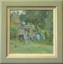 Load image into Gallery viewer, 12 x 12 inch oil painting, with various leaning sheds at the back of an old workman&#39;s cottage, with a figure walking towards us on a grassy path between the sheds and some trees. Shows green/grey frame with buff inner slip
