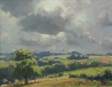 Load image into Gallery viewer, A view across the fields at Lyndon, with a big Oak tree in left foreground of stubble field, with distant blue trees and green fields and a lively, cloudy sky.
