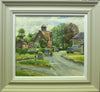 15 x 17 inch oil painting of Lyndon village, looking towards the road to Wing with brick cottages on the left, stone house on the right, with some parked cars, and a couple on bikes turning into the road to North Luffenham where Picks Barn Cafe is. Also shows the stone-coloured frame with a white inner slip.
