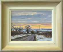 Load image into Gallery viewer, Oil painting with view towards Bisbrooke across snow-covered fields and dark, bare trees against a yellowy horizon and blue-grey clouds. Painting size 6 x 8 inches. Shows frame with off-white inner edge and silver-gold outer edge.
