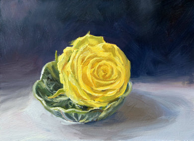 Painting of the head of a yellow rose, sitting in water in a cabbage-leaf dish on a white cloth and a dark, blueish background