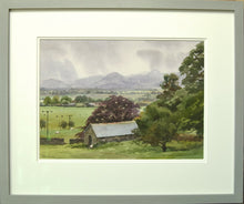 Load image into Gallery viewer, 10x14 inch watercolour depicting a damp, drizzly day from Millbeck in the Lake District, with lots of pale washes describing the mountains in the murk and a barn and tree in the foreground. Shows the double-mounted frame with a grey outer frame moulding.
