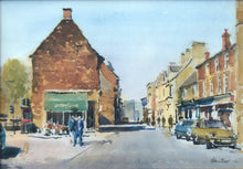 Load image into Gallery viewer, Print of a watercolour painting of High Steet East, Uppingham, Iconic view of the shops on the right, and what was a flower shop occupying the single, ancient building on the left, with several figures so deftly described, strong shadows across the road.
