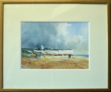 Load image into Gallery viewer, 9.5 x 14 inch watercolour of the chalk cliffs at Hunstanton, set against a dark, moody sky taking up two thirds of the picture plane, with several figures on the beach, with some splattering conveying beach detritus. Gold frame moulding with a double cream/white mount.
